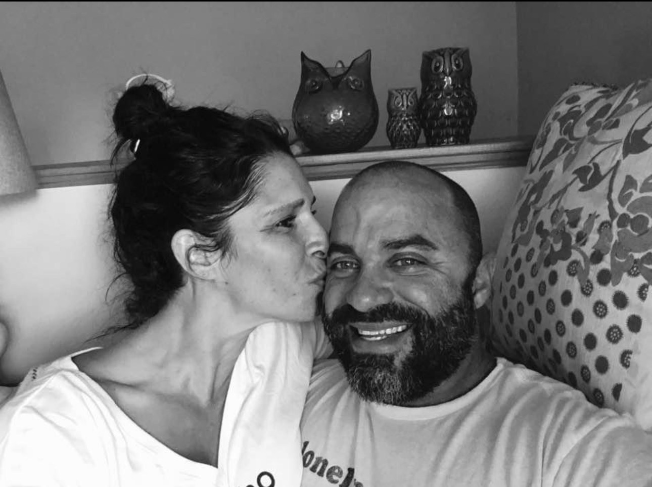 A black-and-white candid of Anthony Castore being kissed on the cheek by his fianc&eacute;e Julie.